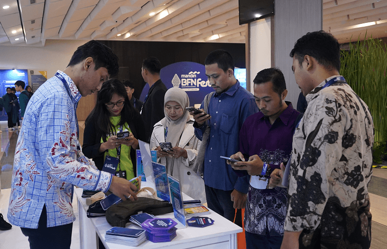 Pengunjung menjelajahi produk fintech di stan pameran